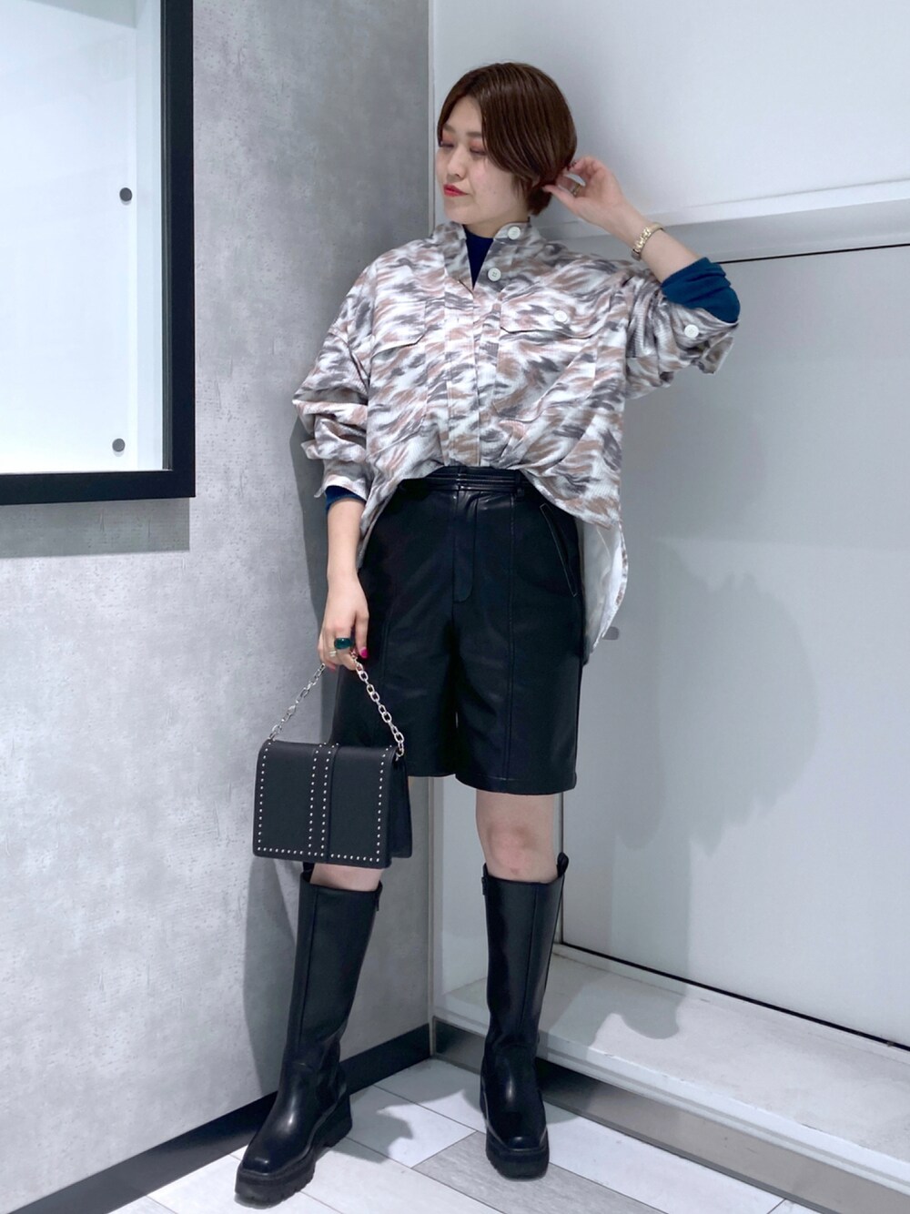 ブラック系のその他パンツ、ホワイト系のその他アウター、グリーン系のニット/セーターを着用したレディースの秋コーディネートの1枚目の写真