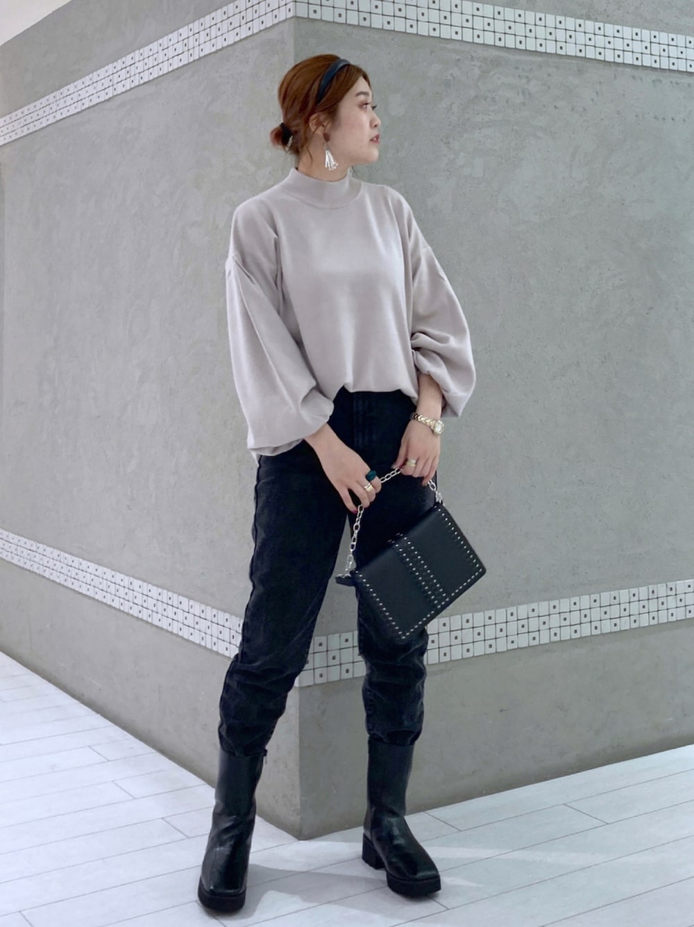 ベージュ系のニット/セーター、ブラック系のショルダーバッグ、ブラック系のデニムパンツを着用したレディースの秋コーディネートの1枚目の写真