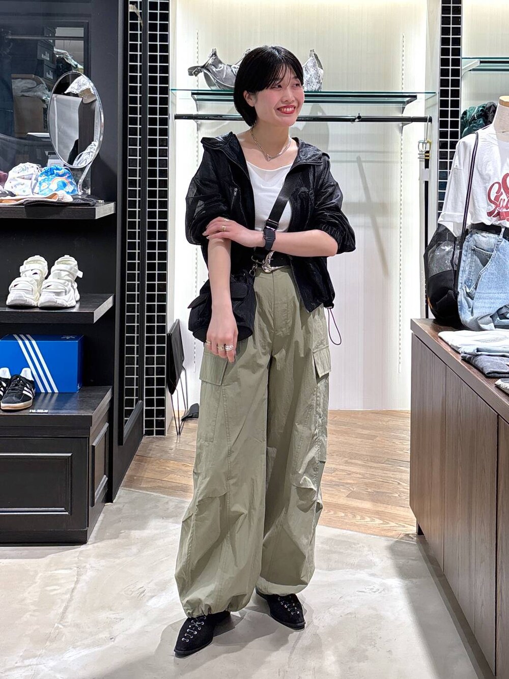 ブラック系のパンプス、グリーン系のカーゴパンツ、ブラック系のブルゾンを着用したレディースの春コーディネートの1枚目の写真