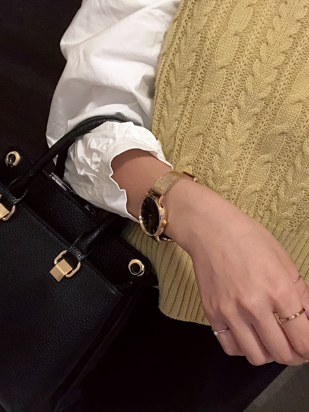 ブラック系のショルダーバッグ、ゴールド系のアナログ腕時計を着用したレディースの冬コーディネートの1枚目の写真