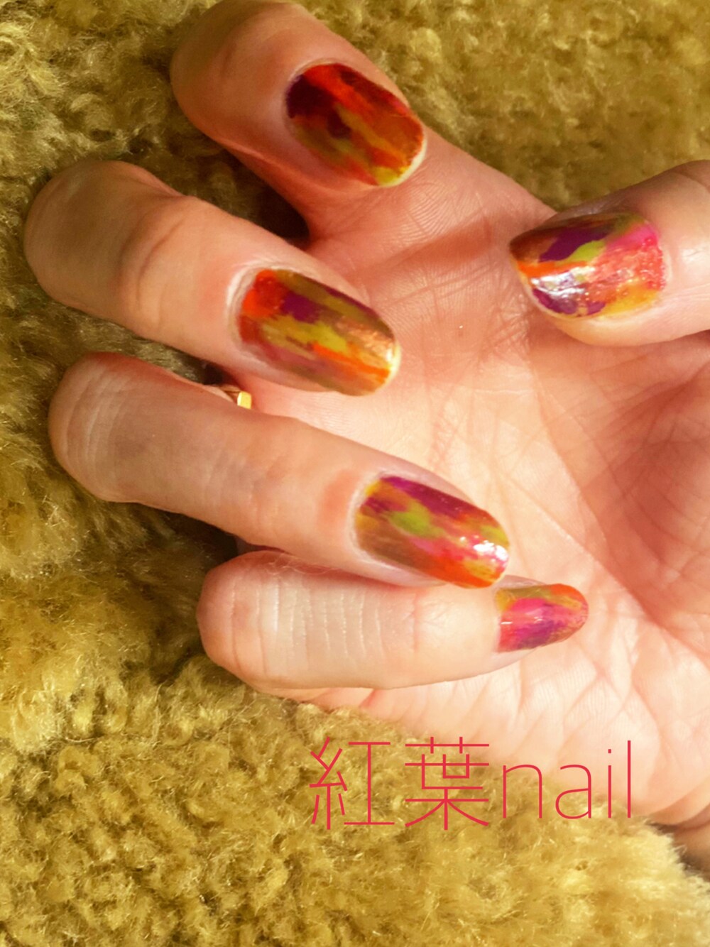 レッド系のマニキュア/ジェルネイルを着用したレディースの秋コーディネートの1枚目の写真