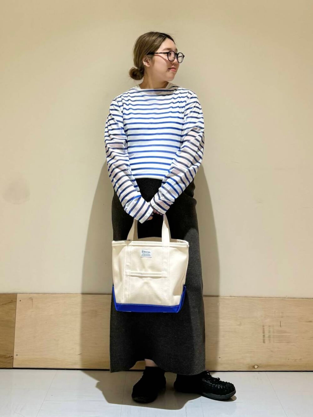 グレー系のスカート、ブルー系のTシャツ/カットソーを着用したレディースの春コーディネートの1枚目の写真