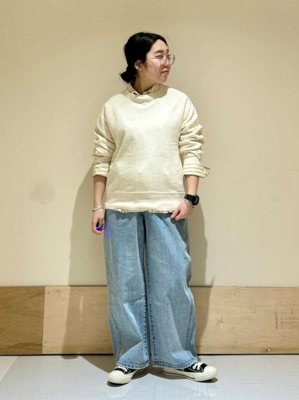 ブルー系のデニムパンツ、ホワイト系のスウェットを着用したレディースの冬コーディネートの1枚目の写真