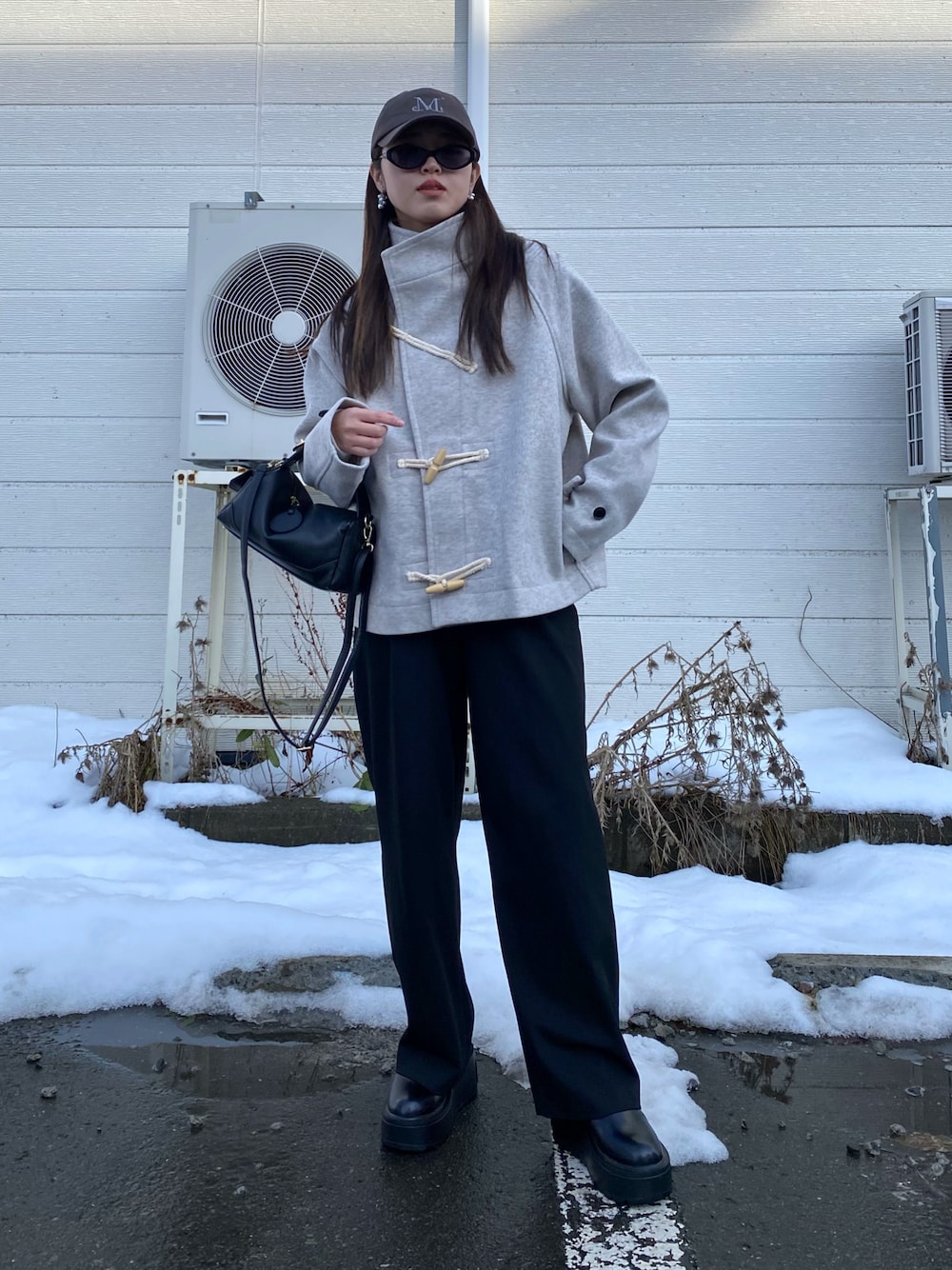 ブラック系のブーツ、ホワイト系のダッフルコート、ブラック系のハンドバッグを着用したレディースの秋コーディネートの1枚目の写真