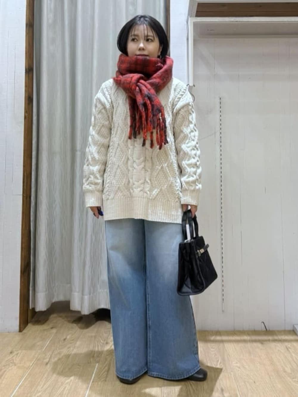 ホワイト系のニット/セーター、ブルー系のデニムパンツ、ブラック系のトートバッグを着用したレディースの冬コーディネートの1枚目の写真