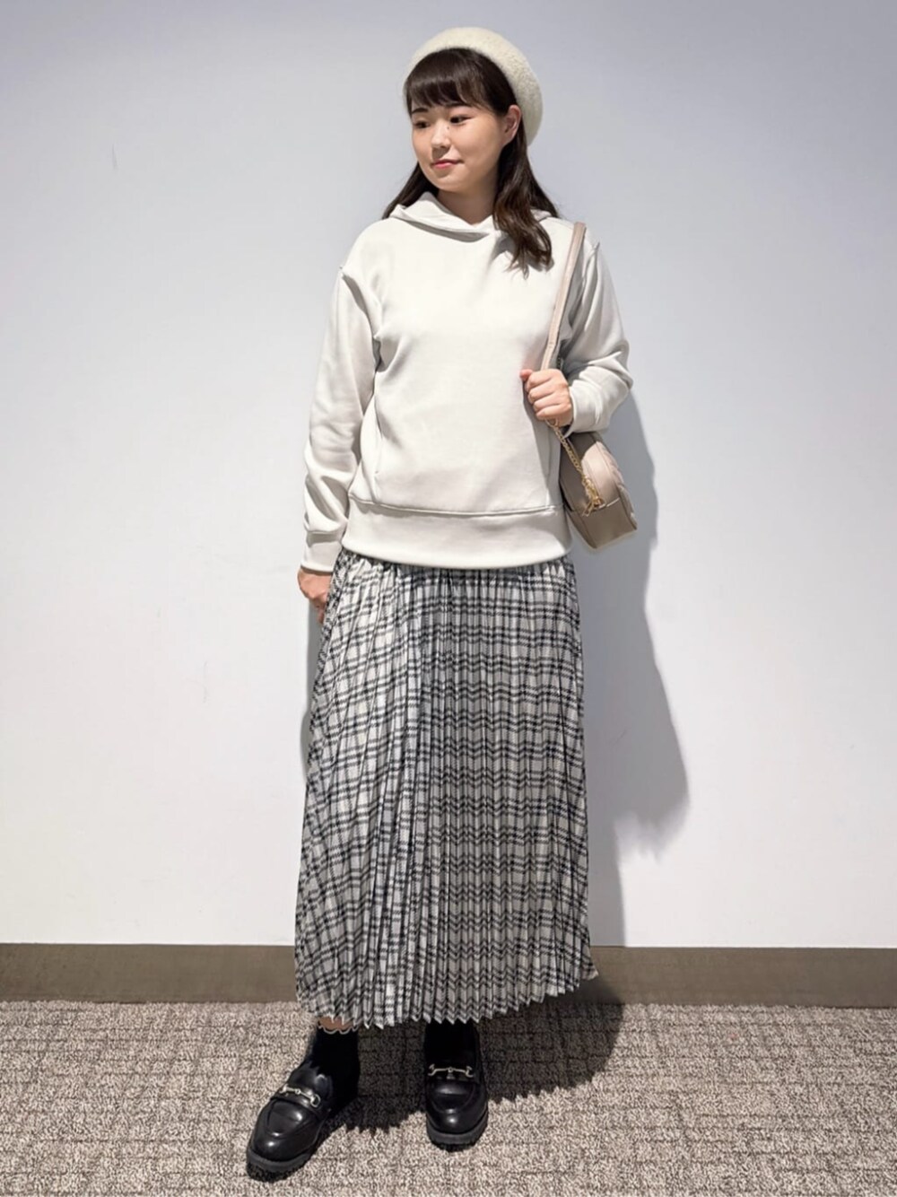 ブラック系のその他シューズ、グレー系のショルダーバッグ、ベージュ系のパーカーを着用したレディースの秋コーディネートの1枚目の写真