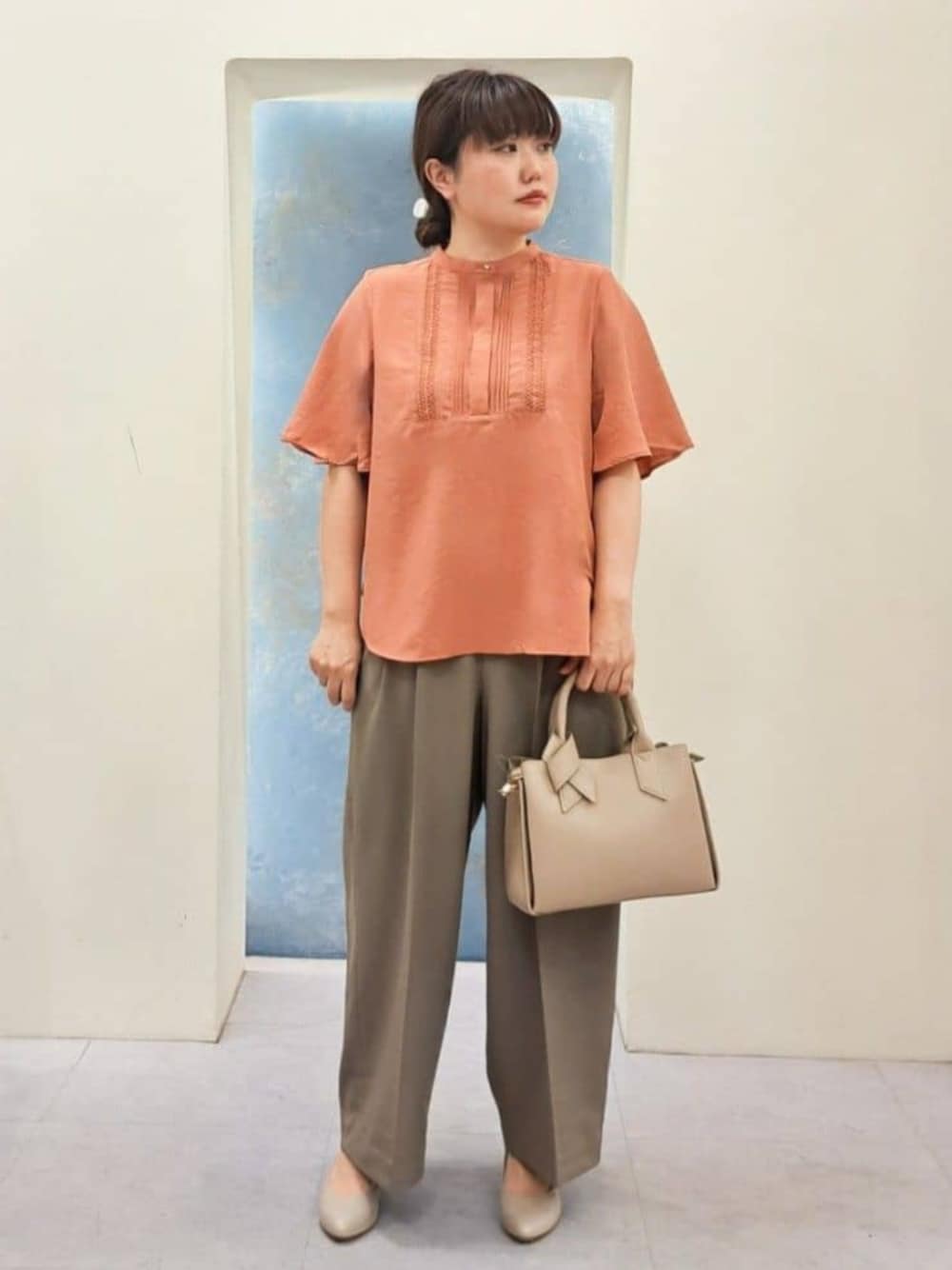 ベージュ系のトートバッグ、ブラック系のシャツ/ブラウス、オレンジ系のシャツ/ブラウスを着用したレディースの夏コーディネートの1枚目の写真