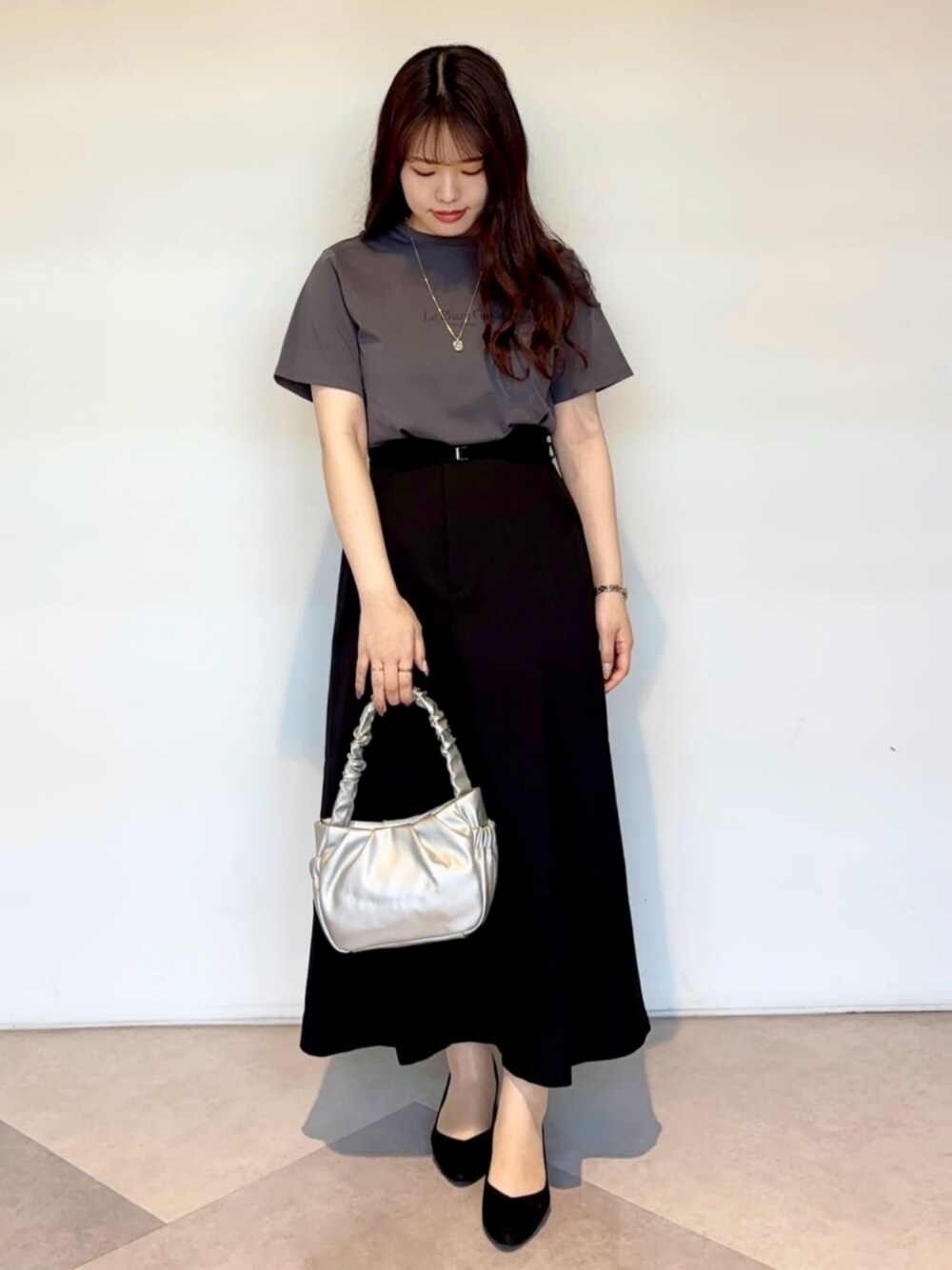ブラック系のパンプス、グレー系のTシャツ/カットソー、ブラック系のスカートを着用したレディースの春コーディネートの1枚目の写真