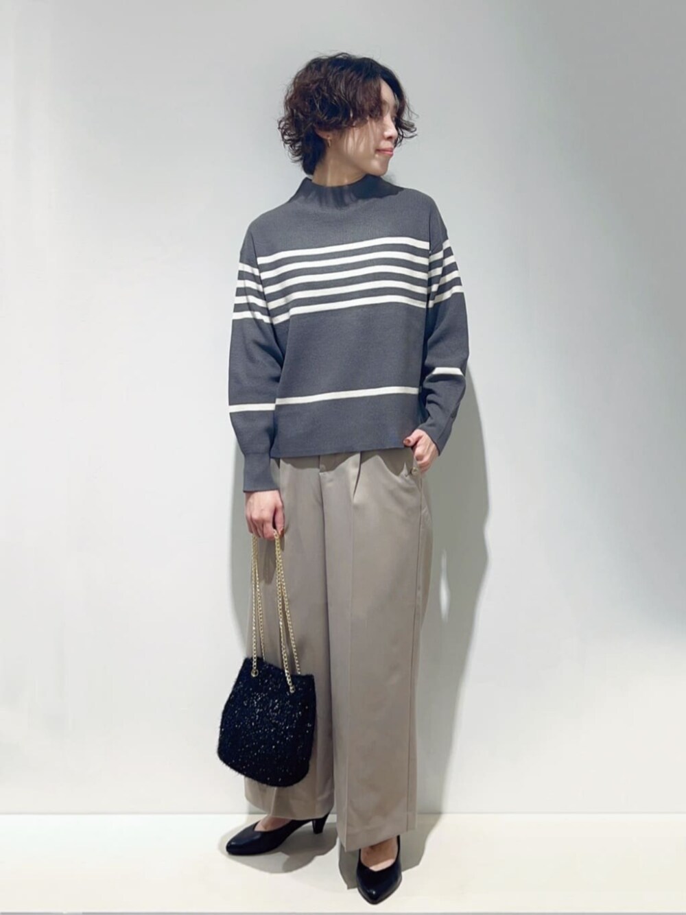 ブラック系のパンプス、ベージュ系のその他パンツ、ブラック系のショルダーバッグを着用したレディースの秋コーディネートの1枚目の写真
