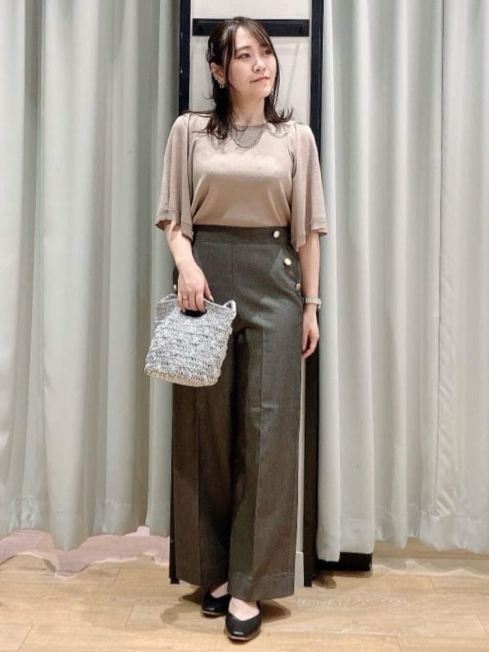 ブラック系のパンプス、シルバー系のショルダーバッグ、ベージュ系のニット/セーターを着用したレディースの春コーディネートの1枚目の写真