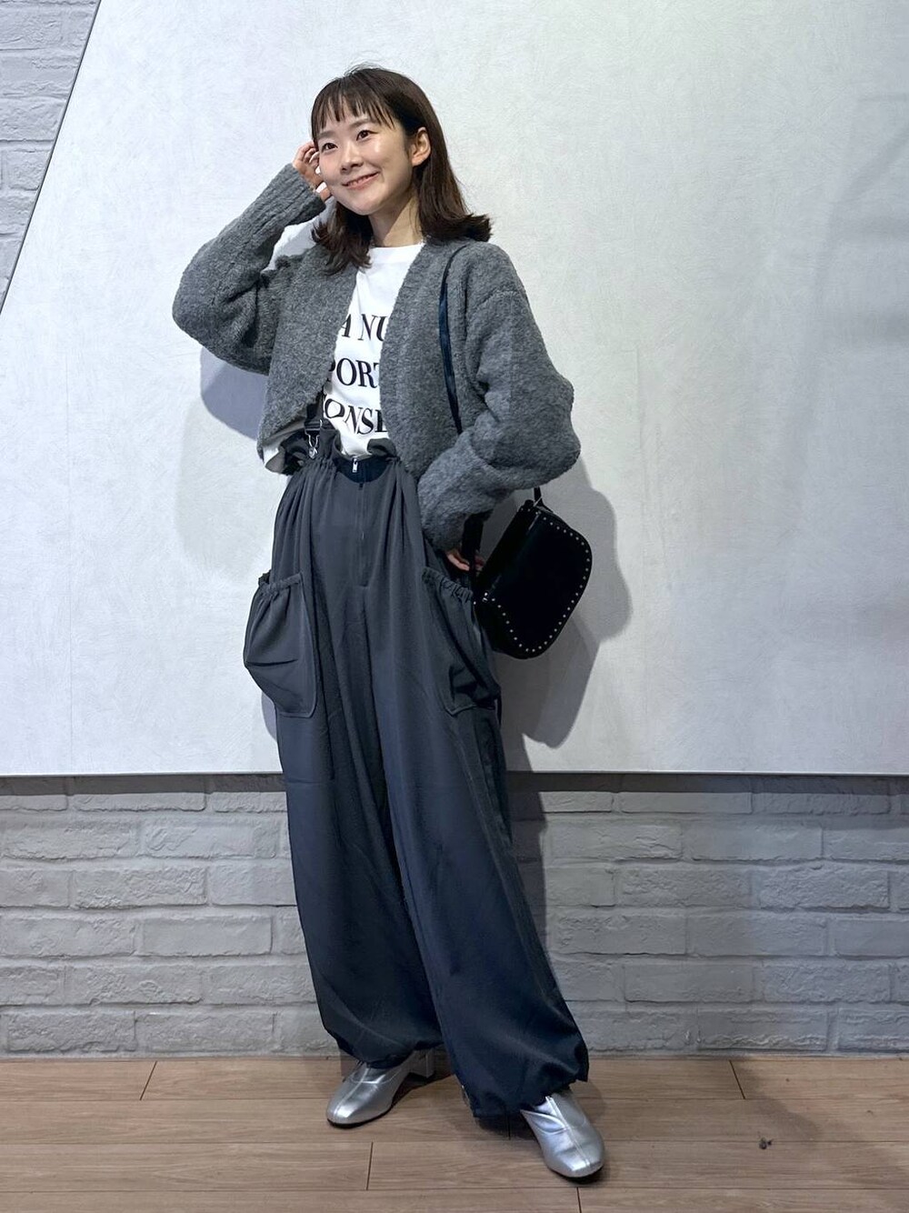 グレー系のワンピース、ブラック系のショルダーバッグ、ホワイト系のTシャツ/カットソーを着用したレディースの秋コーディネートの1枚目の写真