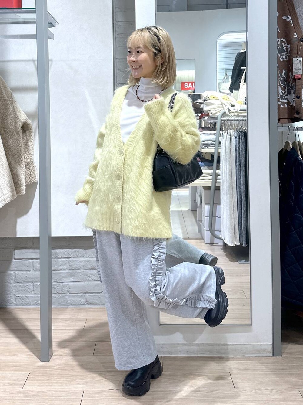 ブラック系のブーツ、イエロー系のカーディガン/ボレロ、グレー系のスウェットパンツを着用したレディースの秋コーディネートの1枚目の写真