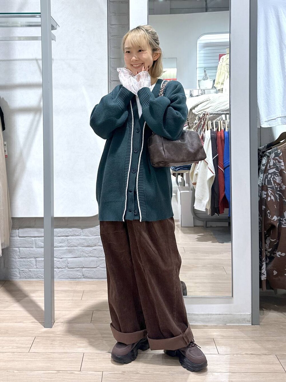 グリーン系のカーディガン/ボレロ、ブラウン系のその他パンツ、ホワイト系のTシャツ/カットソーを着用したレディースの秋コーディネートの1枚目の写真