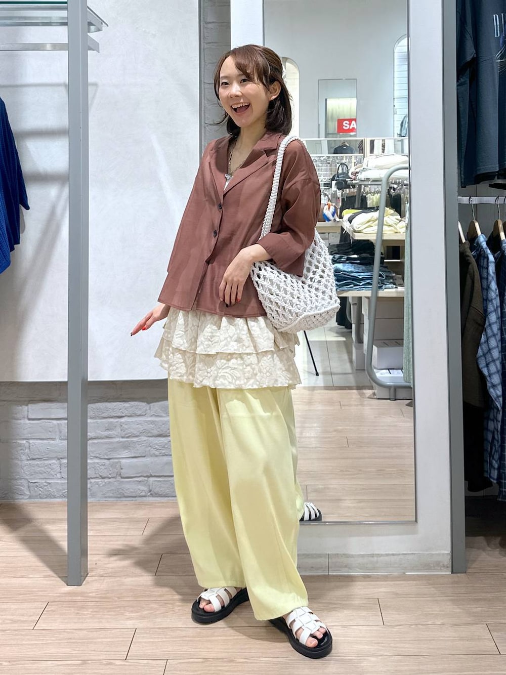 ホワイト系のサンダル、ホワイト系のトートバッグ、ブラウン系のシャツ/ブラウスを着用したレディースの夏コーディネートの1枚目の写真