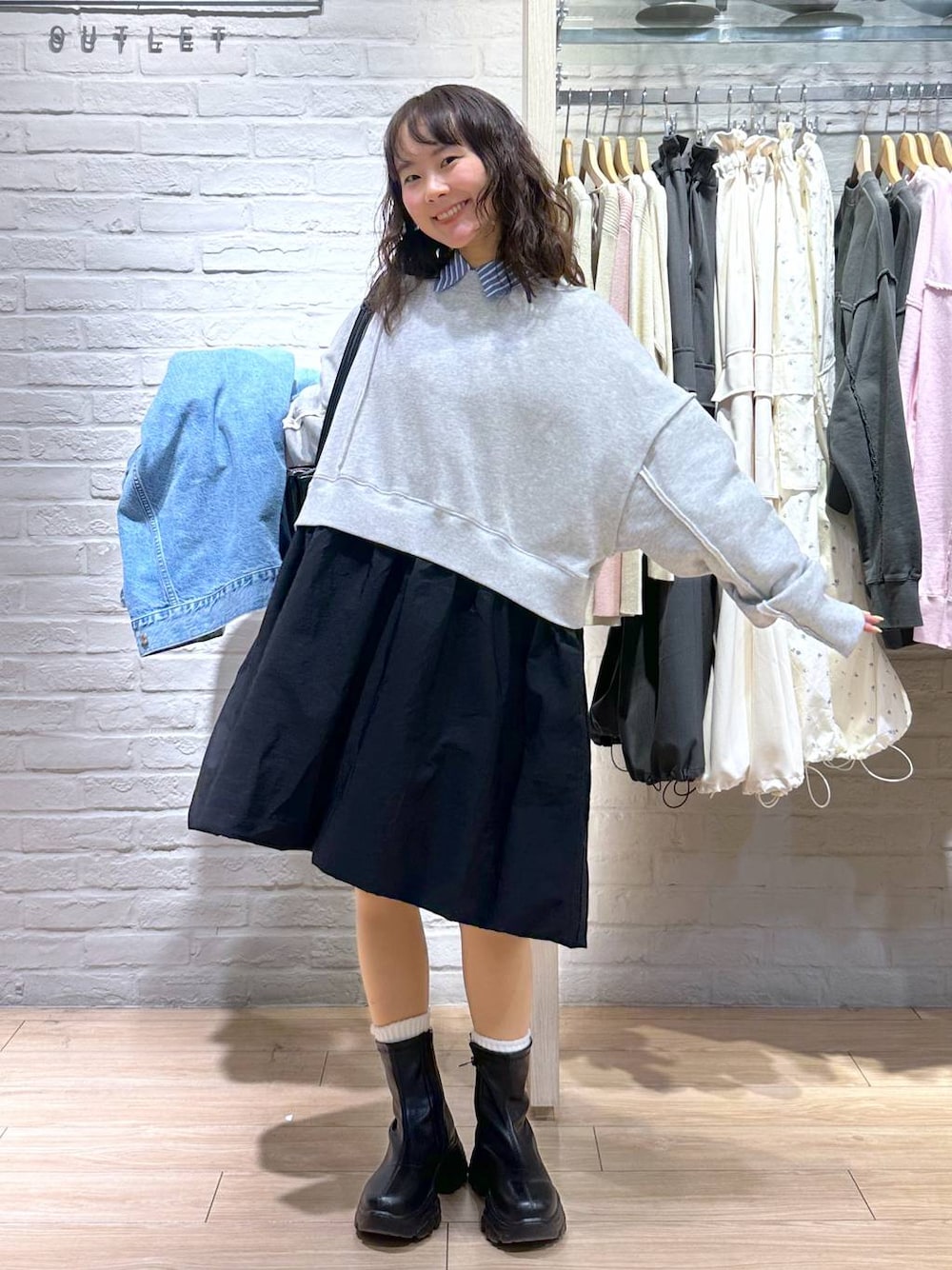 ブルー系のデニムジャケット、ブラック系のショルダーバッグ、ブラック系のブーツを着用したレディースの春コーディネートの1枚目の写真