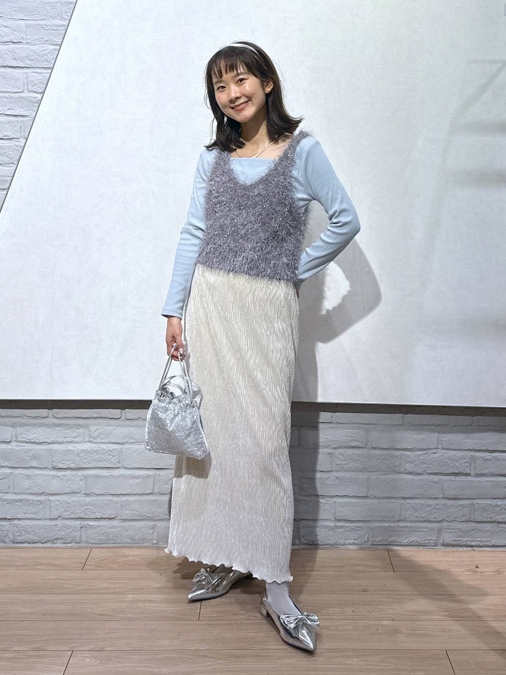 シルバー系のパンプス、グレー系のキャミソール、シルバー系のショルダーバッグを着用したレディースの秋コーディネートの1枚目の写真