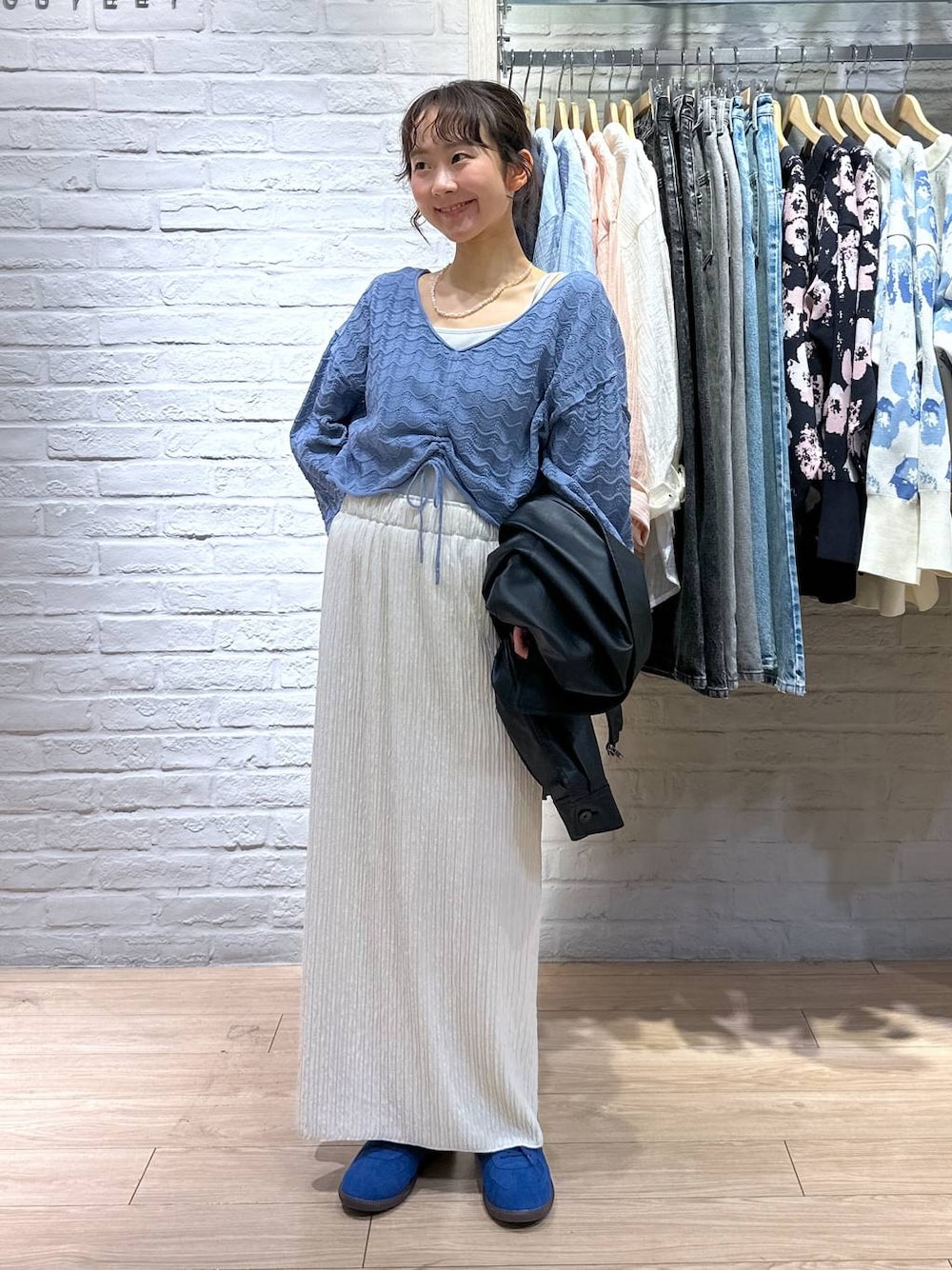 ホワイト系のTシャツ/カットソー、ホワイト系のスカート、ブルー系のスニーカーを着用したレディースの春コーディネートの1枚目の写真