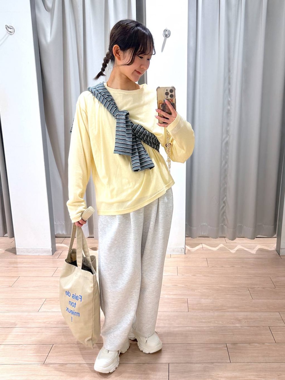 グレー系のスウェットパンツ、イエロー系のTシャツ/カットソー、ベージュ系のトートバッグを着用したレディースの春コーディネートの1枚目の写真