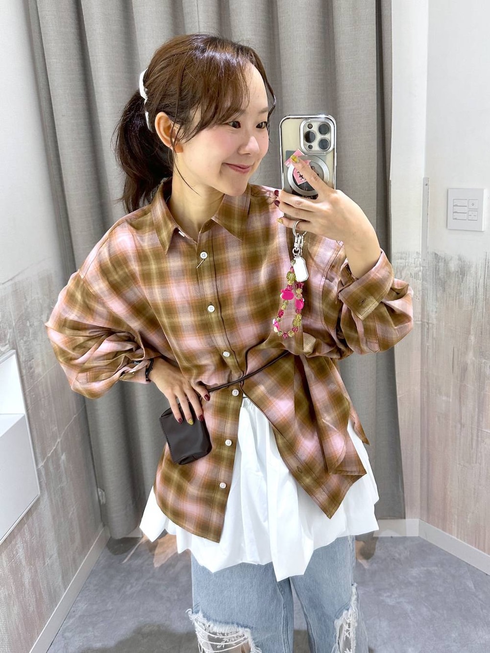 ブラウン系のボディバッグ/ウエストポーチ、ブルー系のデニムパンツ、ピンク系のシャツ/ブラウスを着用したレディースの秋コーディネートの1枚目の写真