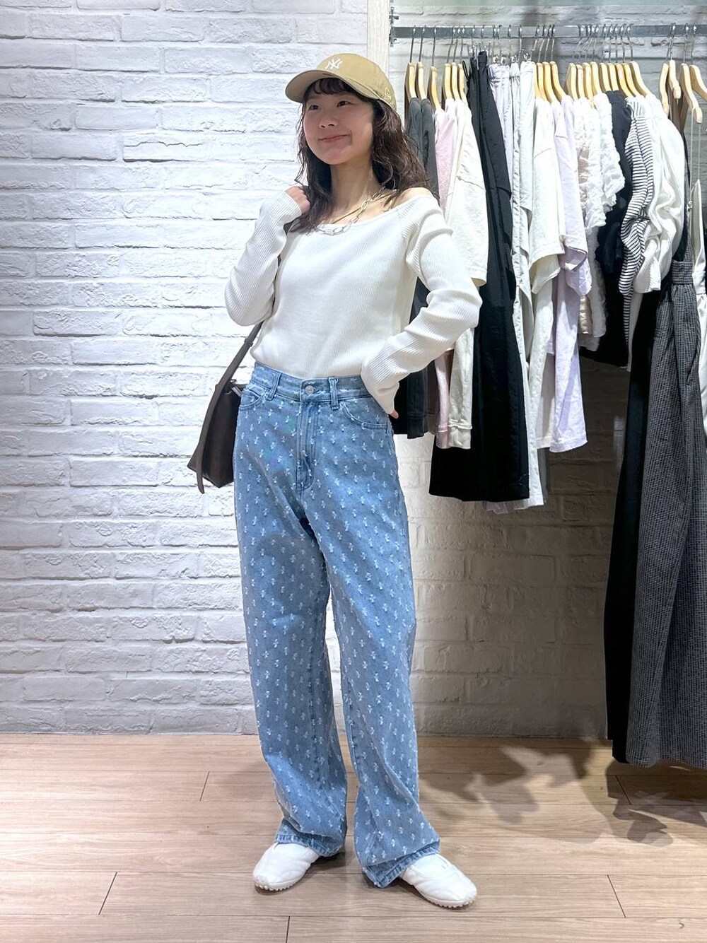 ブルー系のデニムパンツ、ホワイト系のTシャツ/カットソー、ホワイト系のスニーカーを着用したレディースの春コーディネートの1枚目の写真