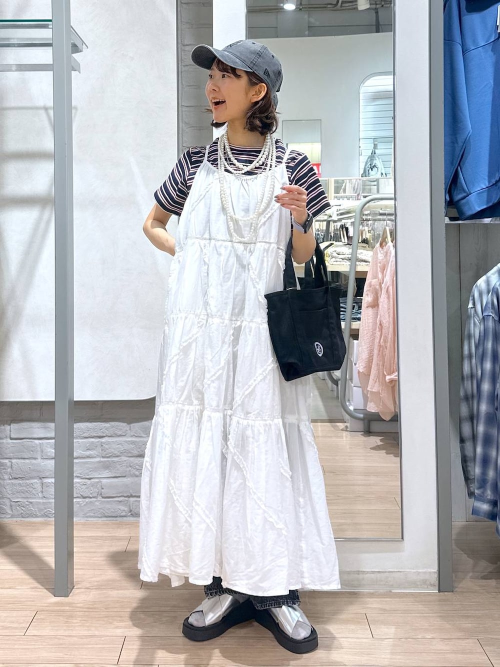 ブルー系のTシャツ/カットソー、ブラック系のデニムパンツ、ブラック系のショルダーバッグを着用したレディースの春コーディネートの1枚目の写真