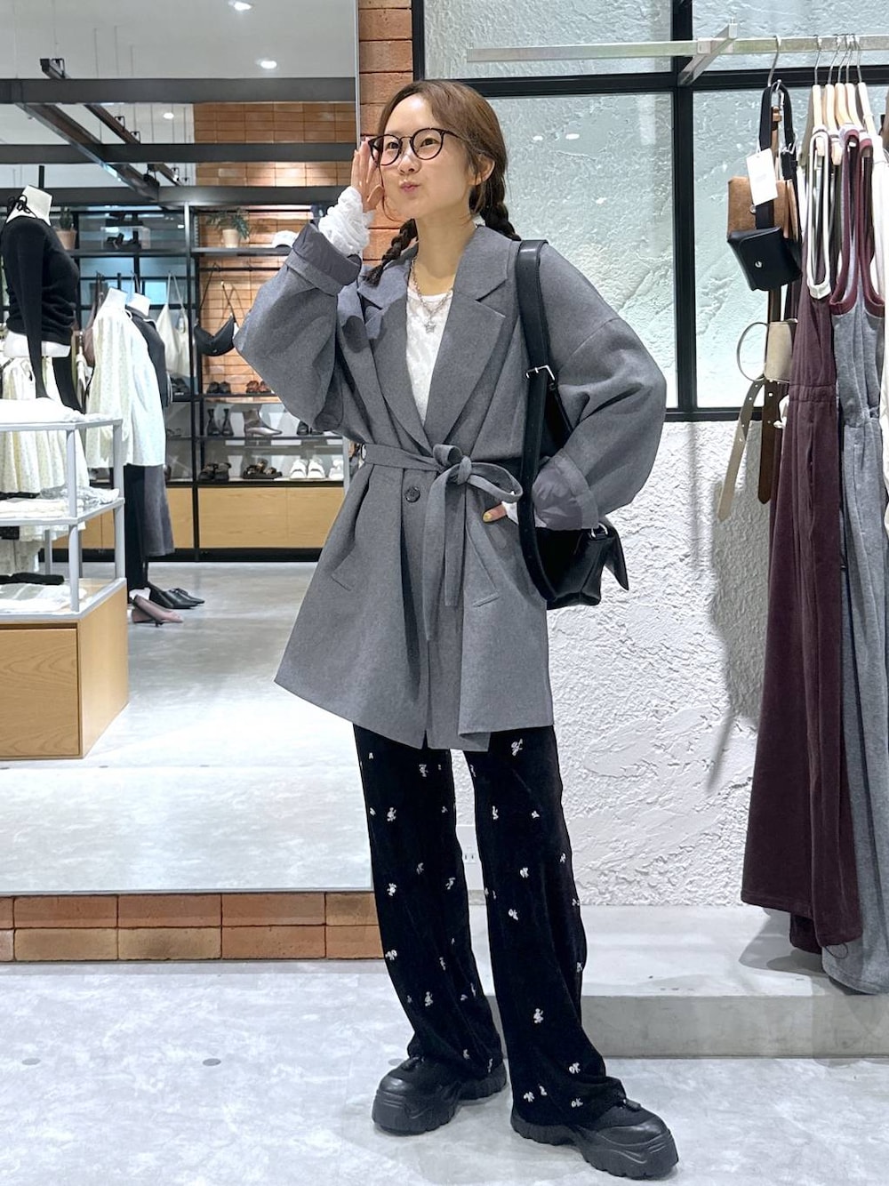 ブラック系のショルダーバッグ、ホワイト系のTシャツ/カットソー、ブラック系のスニーカーを着用したレディースの秋コーディネートの1枚目の写真