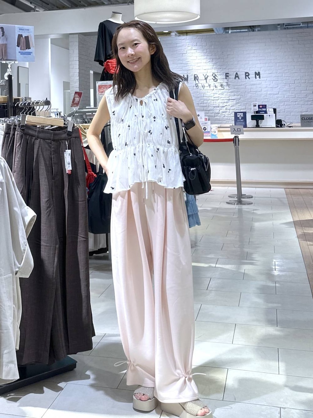 ピンク系のスウェットパンツ、ホワイト系のサンダル、ホワイト系のシャツ/ブラウスを着用したレディースの夏コーディネートの1枚目の写真