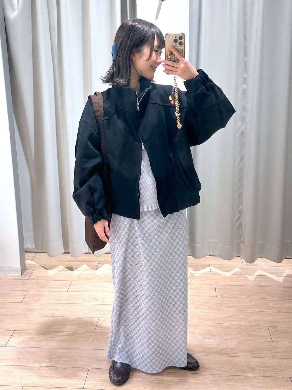 ブラウン系のトートバッグ、ブラウン系のローファー、ブルー系のスカートを着用したレディースの春コーディネートの1枚目の写真