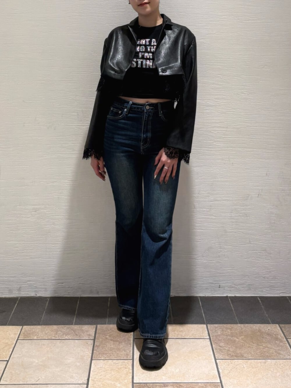 ブルー系のデニムパンツ、ブラック系のブーツ、ブラック系のTシャツ/カットソーを着用したレディースの秋コーディネートの1枚目の写真