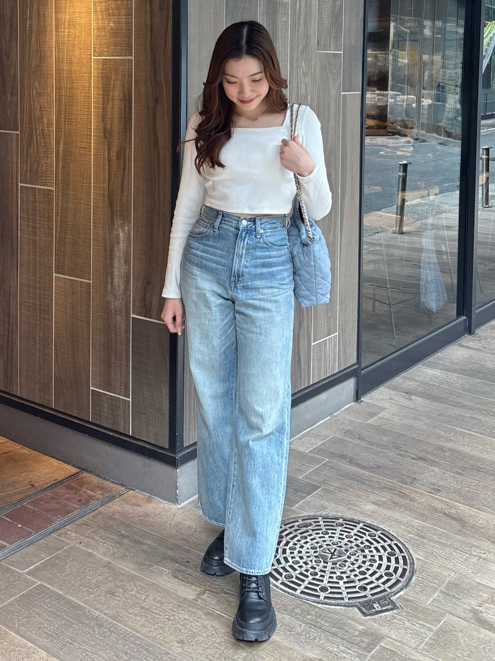 ホワイト系のTシャツ/カットソー、ブルー系のデニムパンツ、ブラック系のブーツを着用したレディースの春コーディネートの1枚目の写真