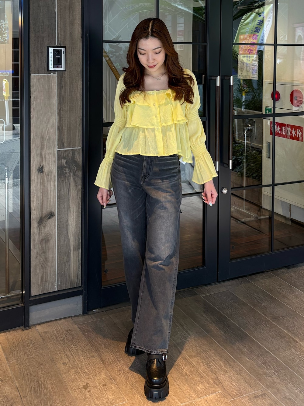 イエロー系のシャツ/ブラウス、ブラック系のデニムパンツ、ブラック系のブーツを着用したレディースの春コーディネートの1枚目の写真