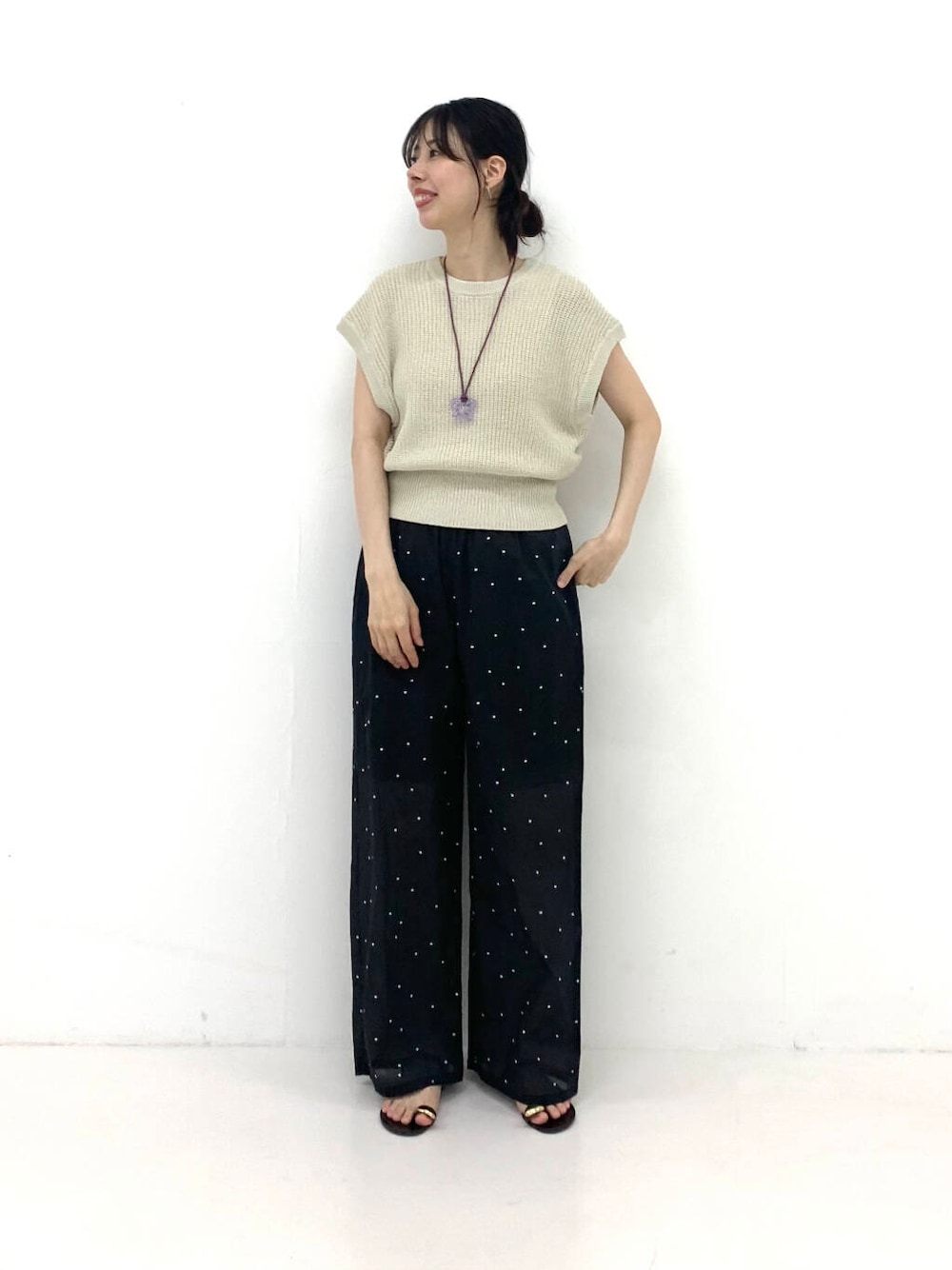 ブラウン系のその他パンツ、ベージュ系のベスト、ブラック系のサンダルを着用したレディースの夏コーディネートの1枚目の写真