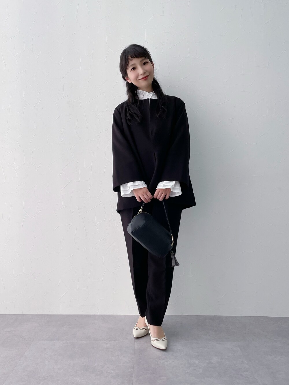 ブラック系のスーツセットを着用したレディースの冬コーディネートの1枚目の写真