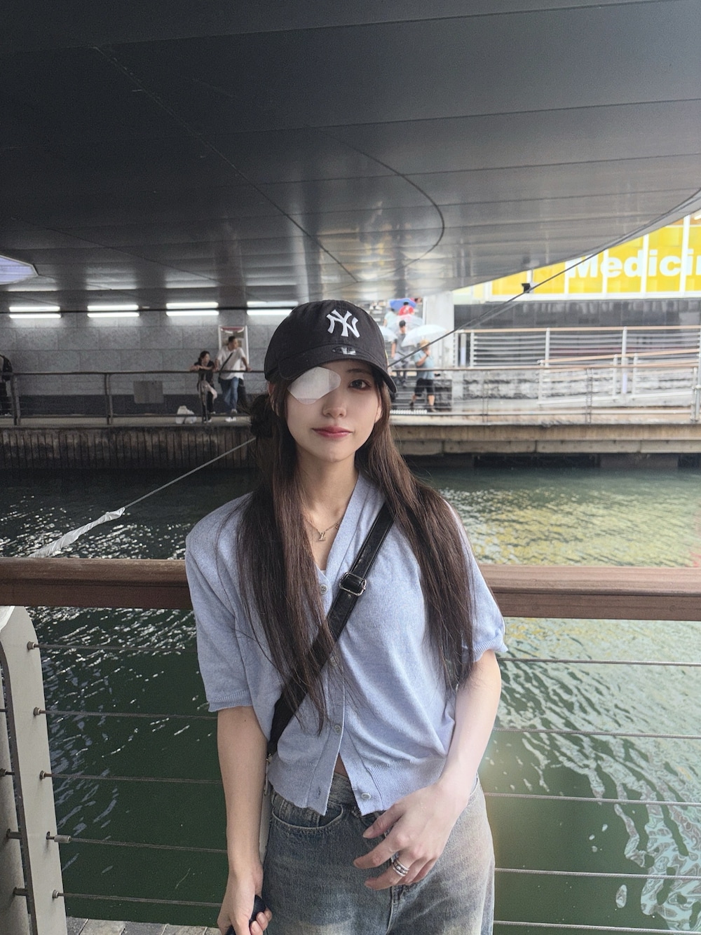 ブルー系のTシャツ/カットソー、ブラック系のキャップを着用したレディースの夏コーディネートの1枚目の写真