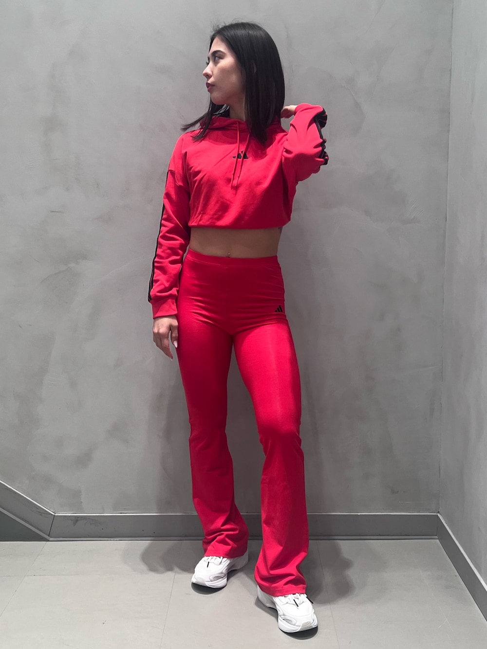 ホワイト系のスニーカー、レッド系のパーカーを着用したレディースの冬コーディネートの1枚目の写真