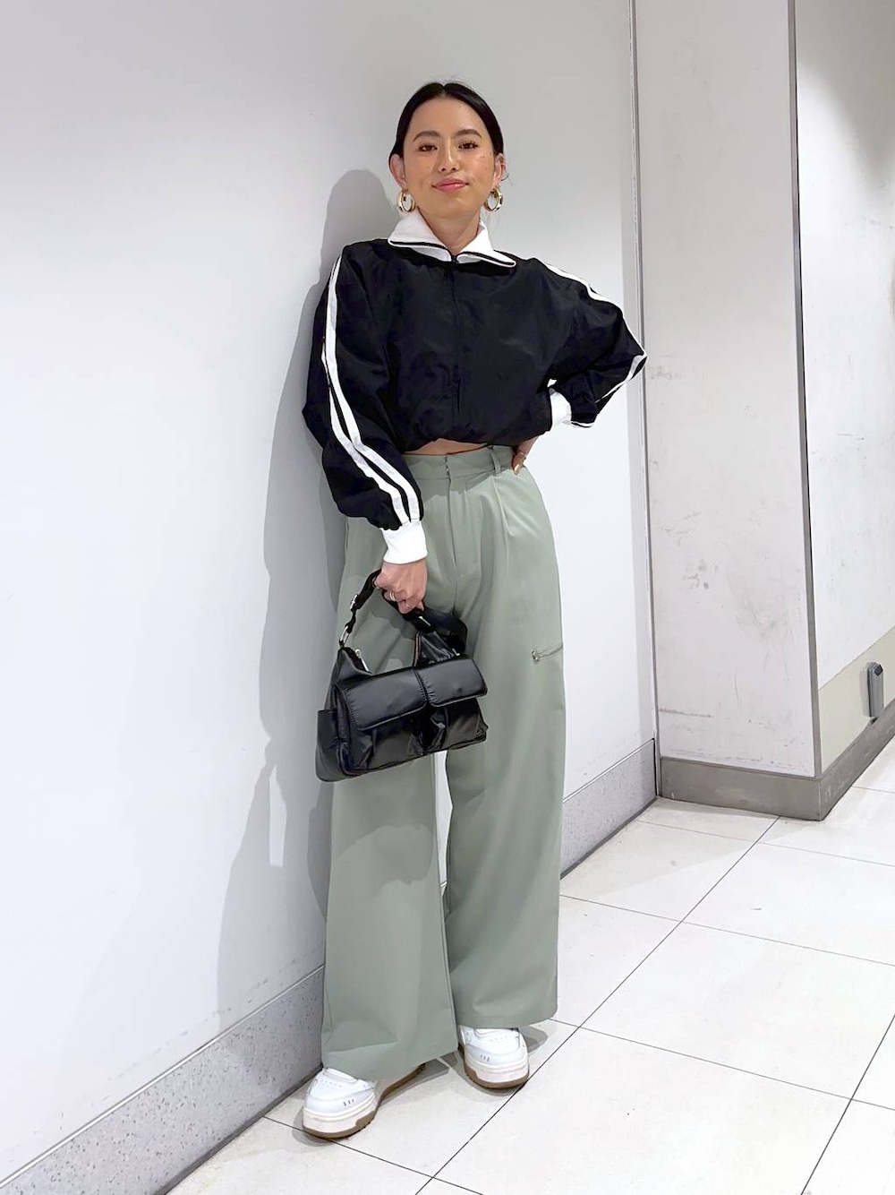 ブラック系のショルダーバッグ、グリーン系のその他パンツ、ブラック系のブルゾンを着用したレディースの冬コーディネートの1枚目の写真