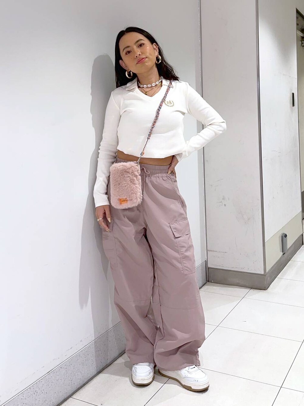 ホワイト系のTシャツ/カットソー、ピンク系のショルダーバッグ、ピンク系のカーゴパンツを着用したレディースの冬コーディネートの1枚目の写真