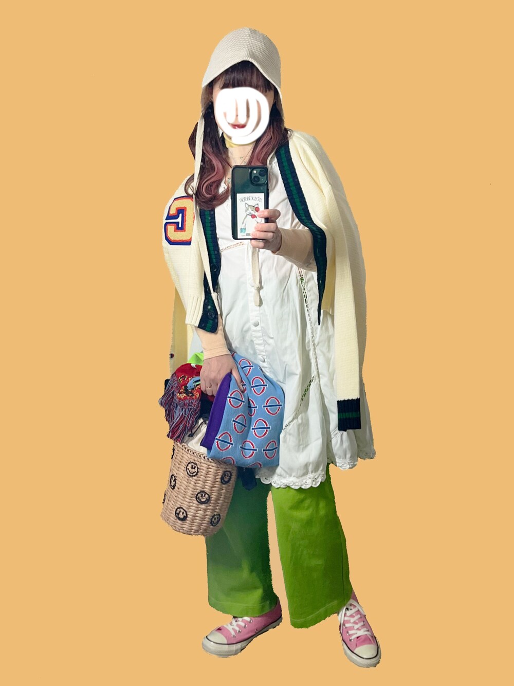 ホワイト系のカーディガン/ボレロ、オレンジ系のTシャツ/カットソー、ベージュ系のかごバッグを着用したレディースの冬コーディネートの1枚目の写真