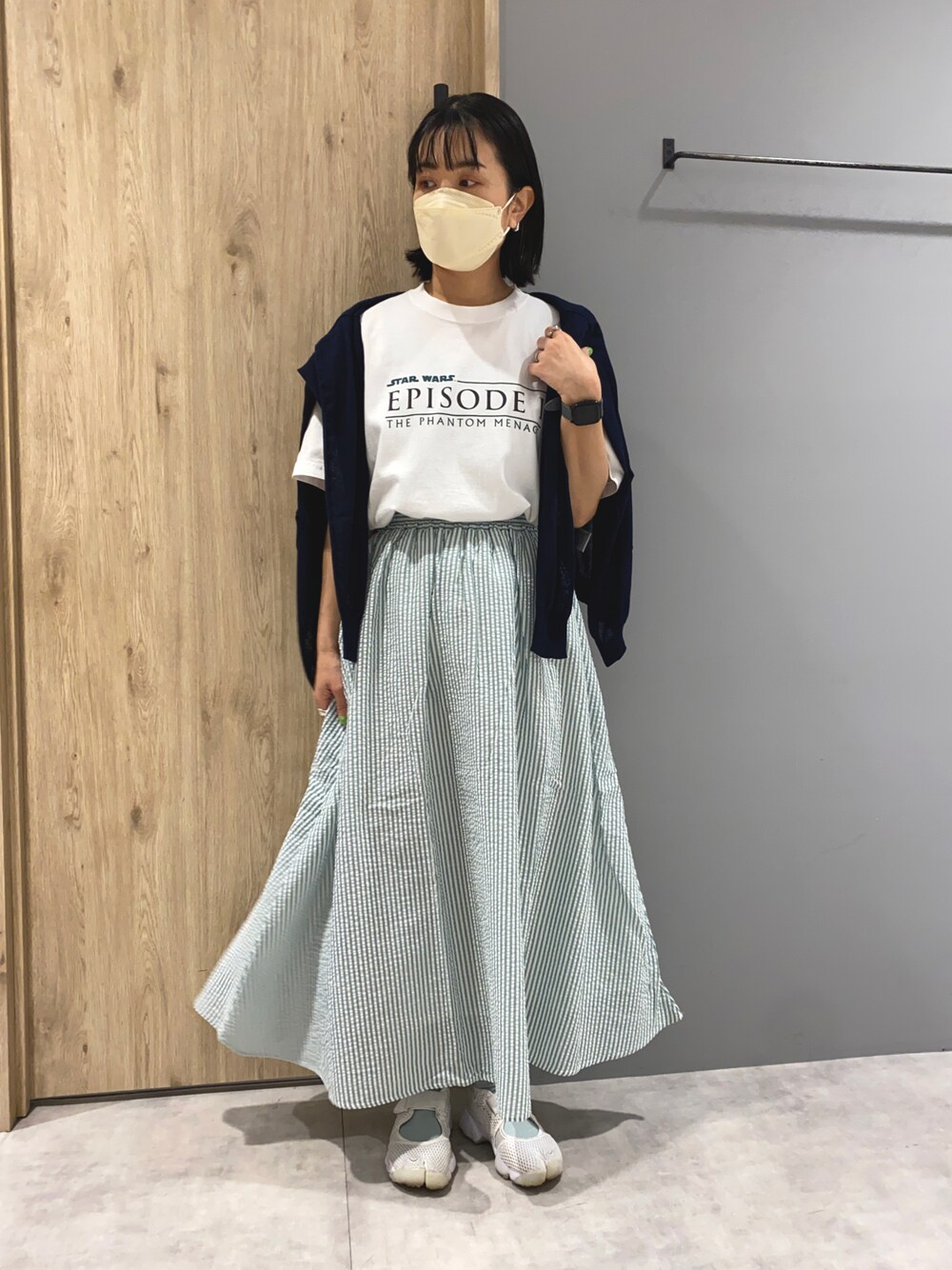 ホワイト系のTシャツ/カットソー、グリーン系のスカート、ブルー系のカーディガン/ボレロを着用したレディースの春コーディネートの1枚目の写真