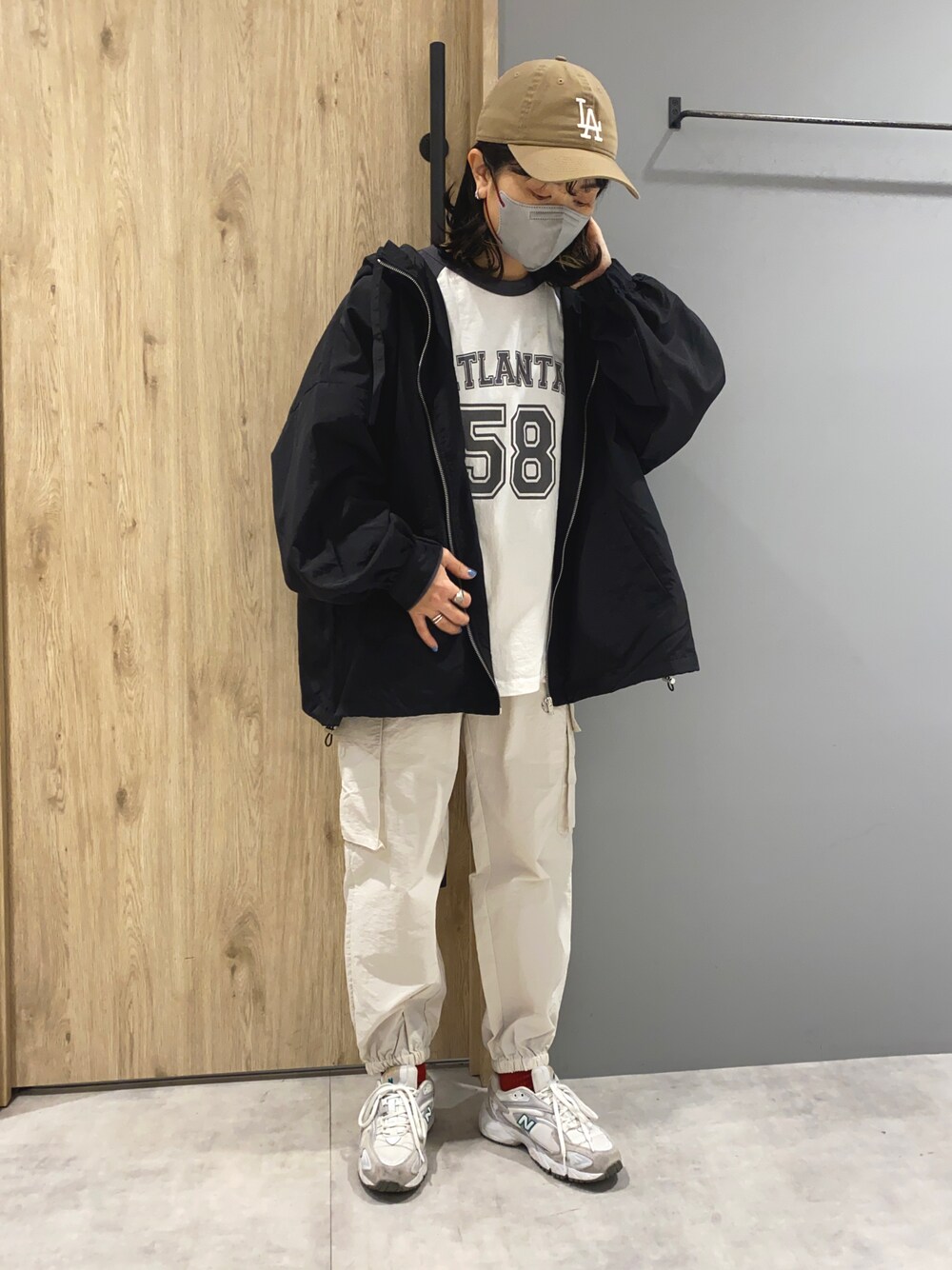 ブラック系のTシャツ/カットソー、ブラック系のマウンテンパーカー、ホワイト系のカーゴパンツを着用したレディースの春コーディネートの1枚目の写真