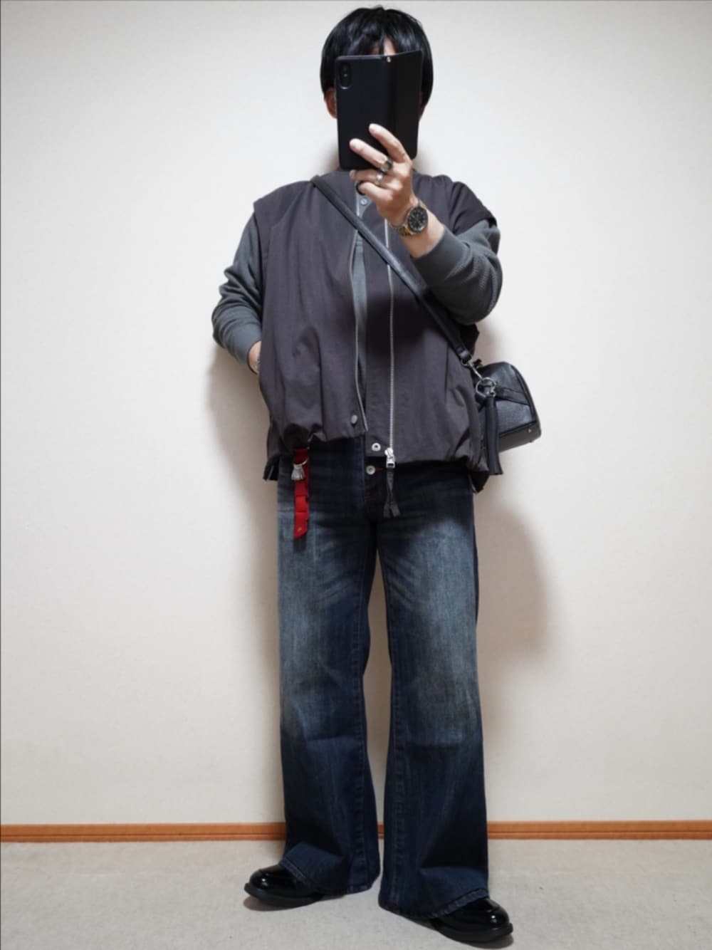 ブラック系のシューズ、ブルー系のデニムパンツ、ブラック系のショルダーバッグを着用したメンズの秋コーディネートの1枚目の写真