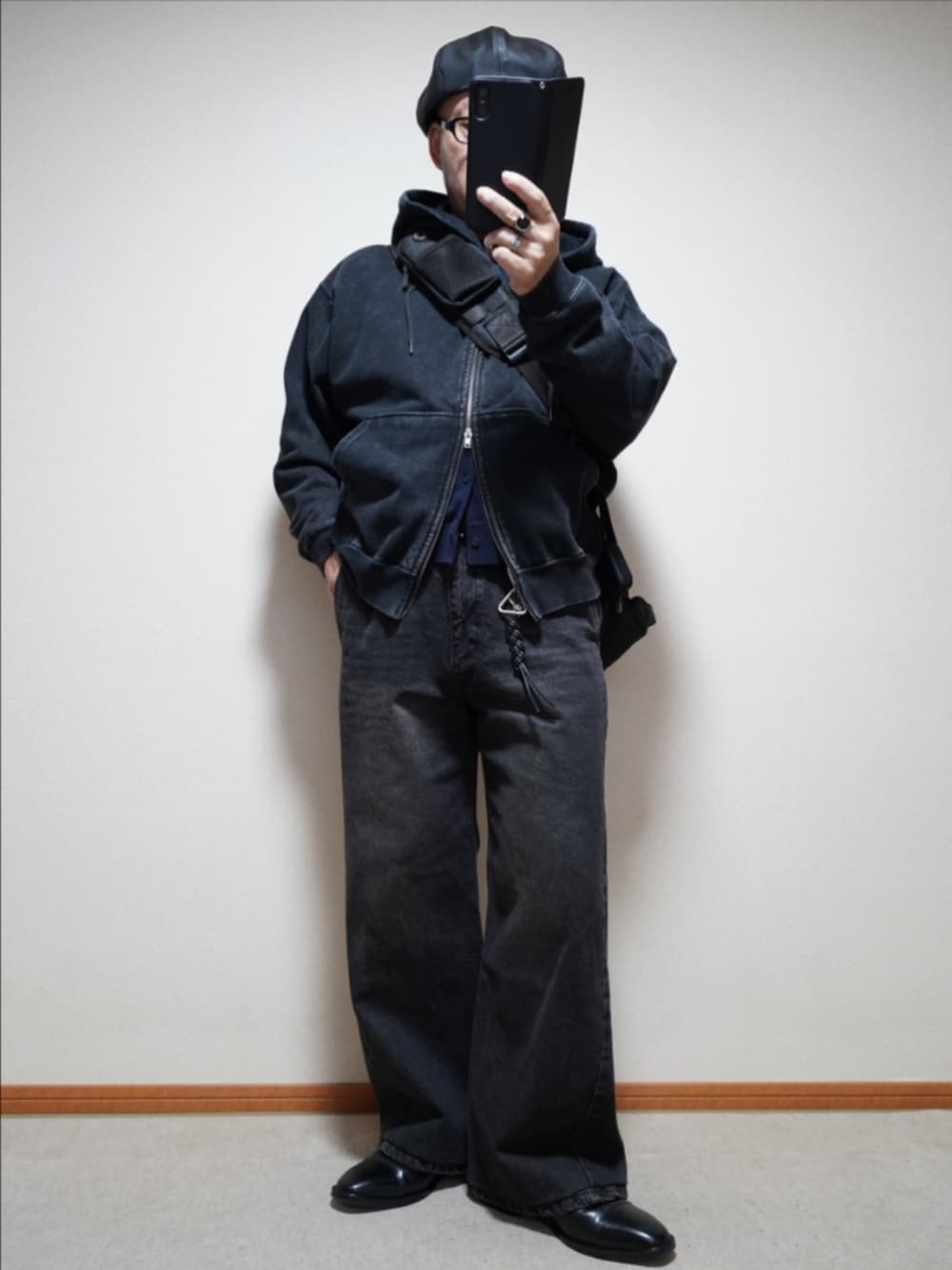 ブラック系のドレスシューズ、ブラック系のデニムパンツ、ブルー系のカーディガン/ボレロを着用したメンズの秋コーディネートの1枚目の写真