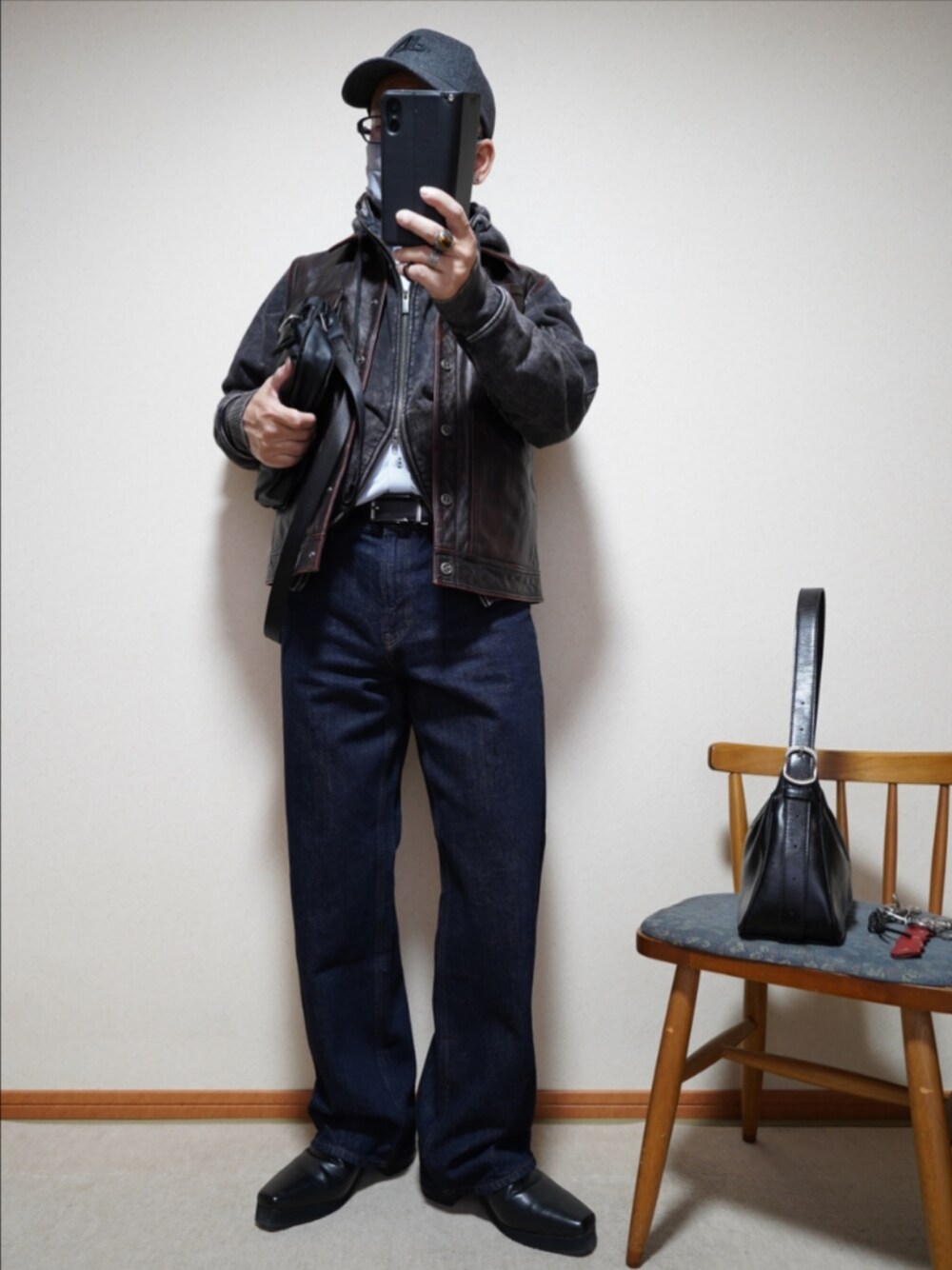 ブラック系のブーツ、ブルー系のデニムパンツ、ブラック系のパーカーを着用したメンズの春コーディネートの1枚目の写真