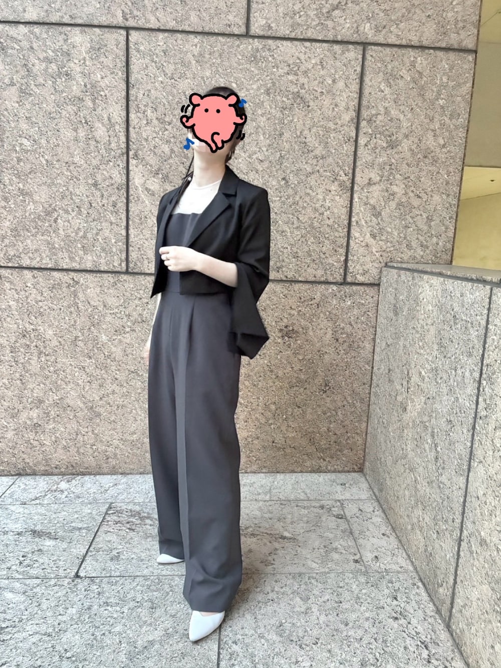 グレー系のパンツドレス、ブラック系のテーラードジャケット、シルバー系のパンプスを着用したレディースの春コーディネートの1枚目の写真