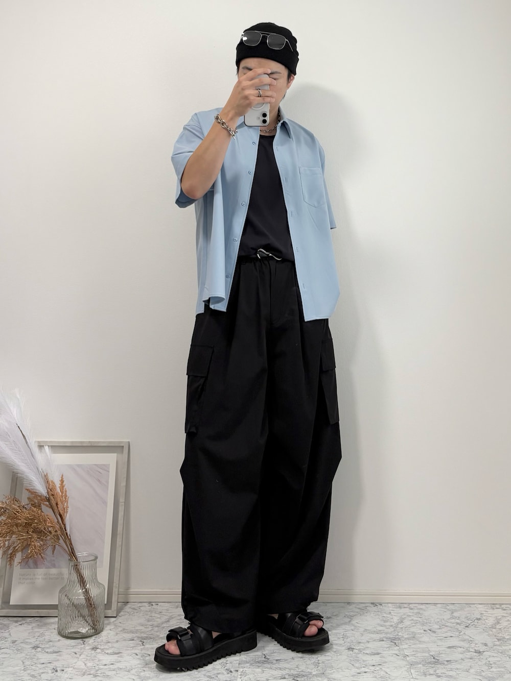 ブルー系のシャツ/ブラウス、ブラック系のタンクトップ、ブラック系のカーゴパンツを着用したメンズの秋コーディネートの1枚目の写真