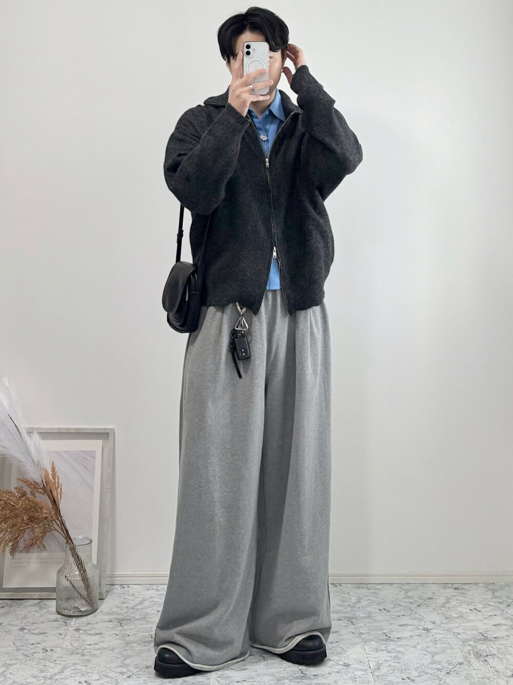 ブラック系のドレスシューズ、グレー系のニット/セーター、グレー系のスウェットパンツを着用したメンズの秋コーディネートの1枚目の写真
