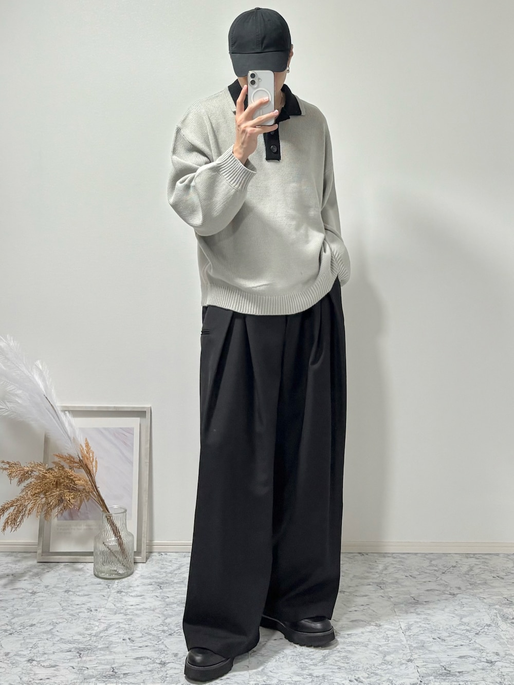 グレー系のニット/セーター、ブラック系のドレスシューズ、ブラック系のスラックスを着用したメンズの秋コーディネートの1枚目の写真