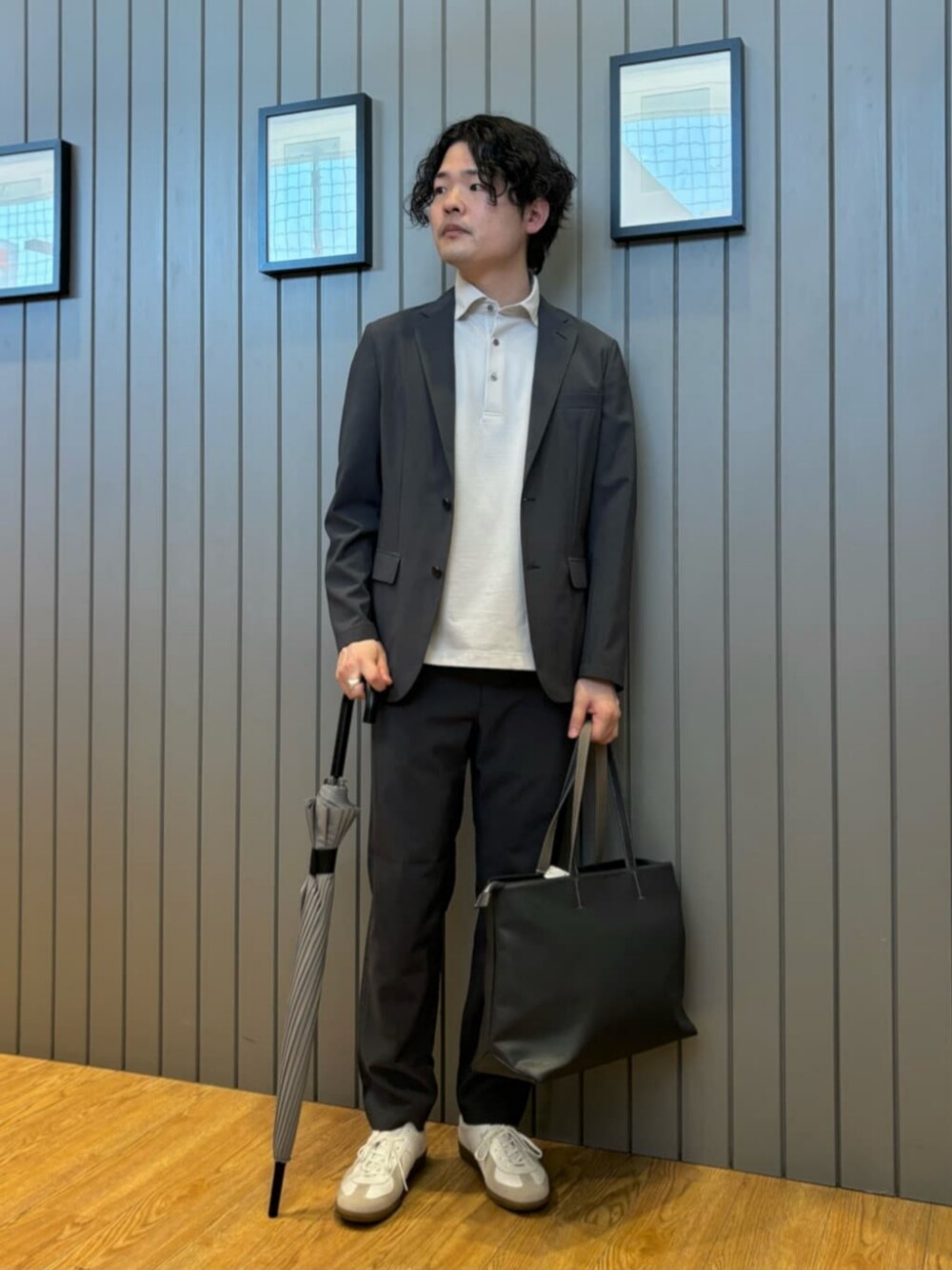 ホワイト系のスニーカー、ブルー系のテーラードジャケット、グレー系のポロシャツを着用したメンズの夏コーディネートの1枚目の写真