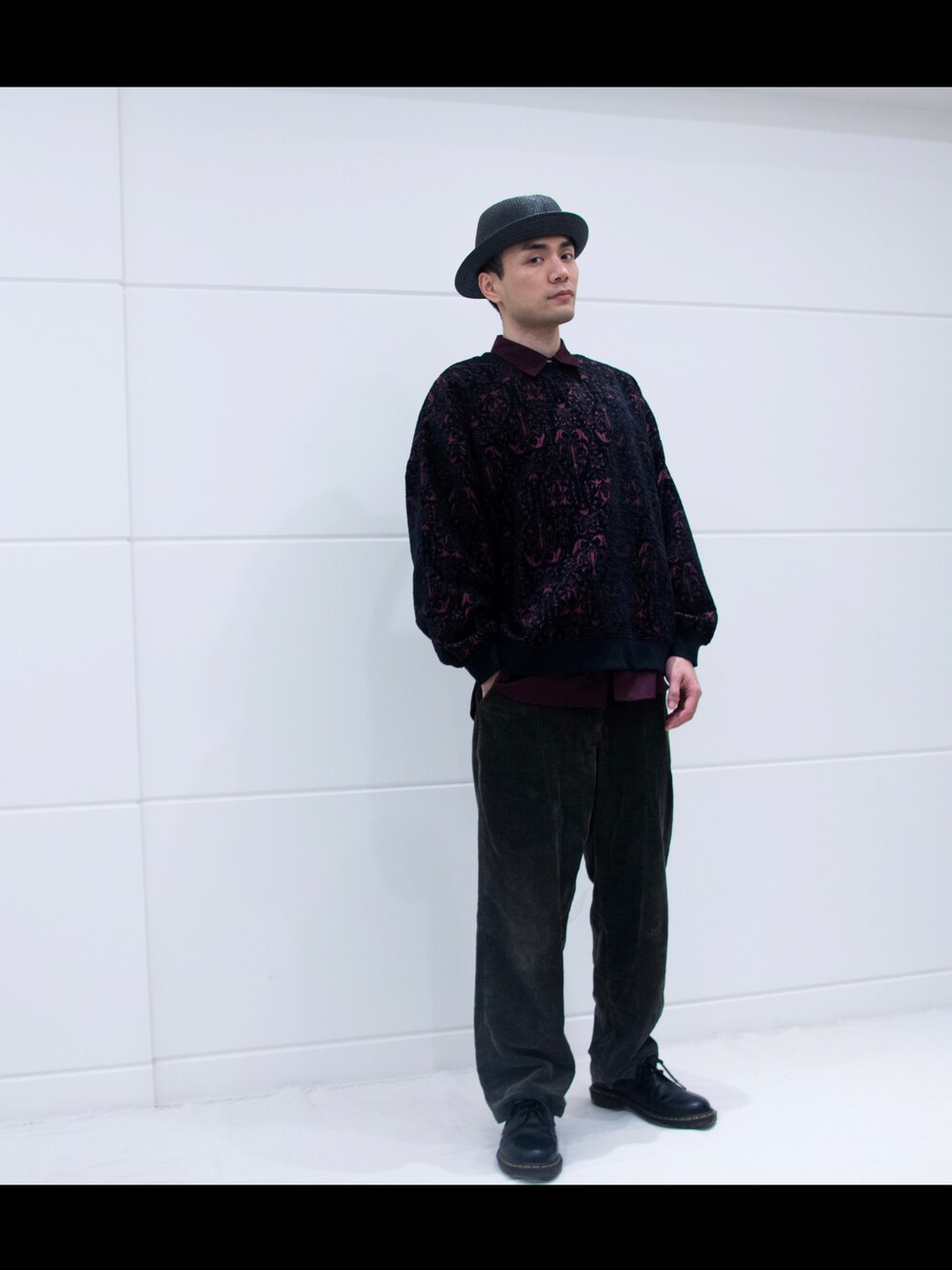 ブラック系のニット/セーター、グリーン系のパンツ、レッド系のシャツ/ブラウスを着用したメンズの冬コーディネートの1枚目の写真