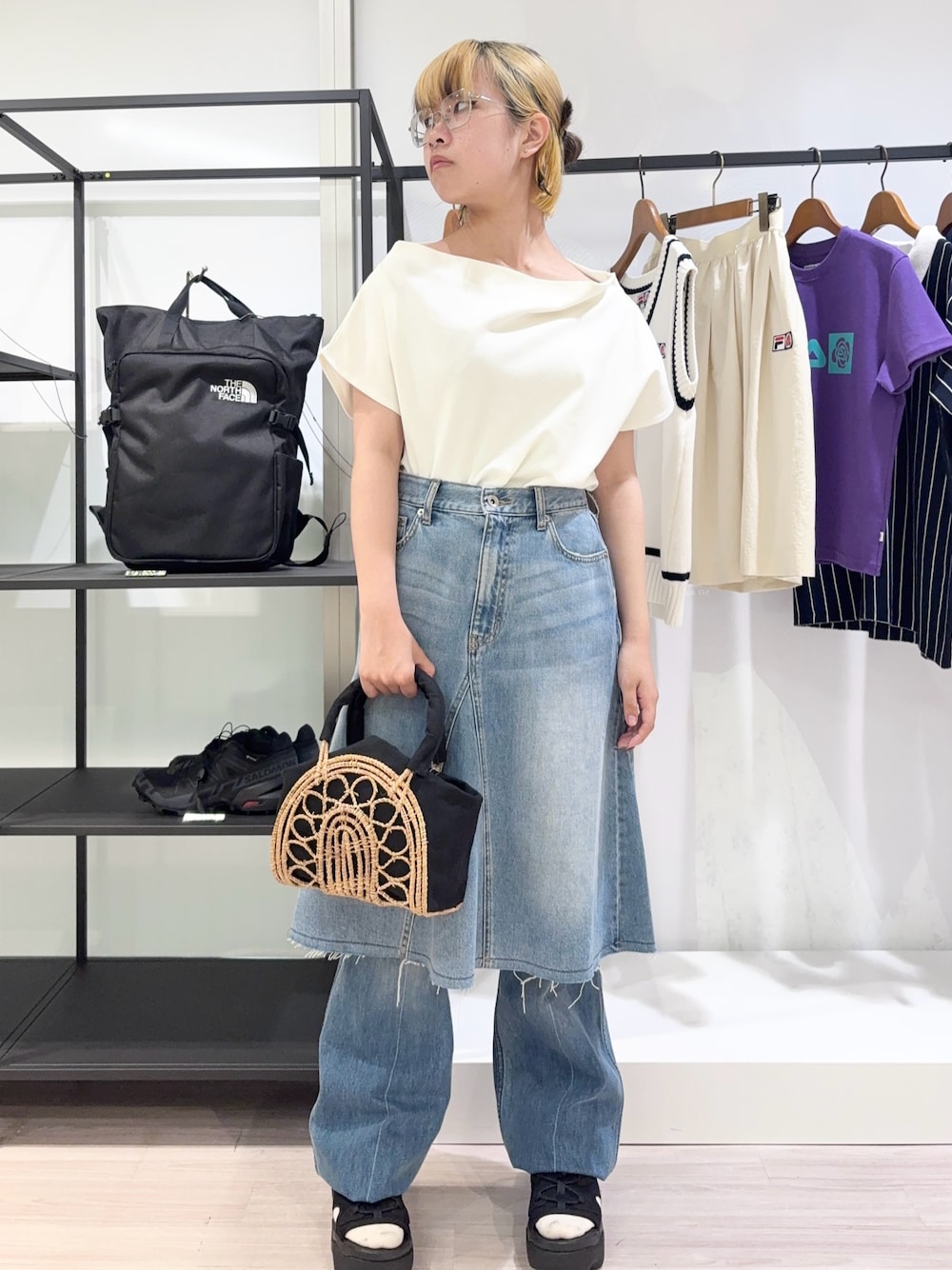 ブラック系のかごバッグ、ブルー系のデニムパンツ、ブラック系のサンダルを着用したレディースの夏コーディネートの1枚目の写真